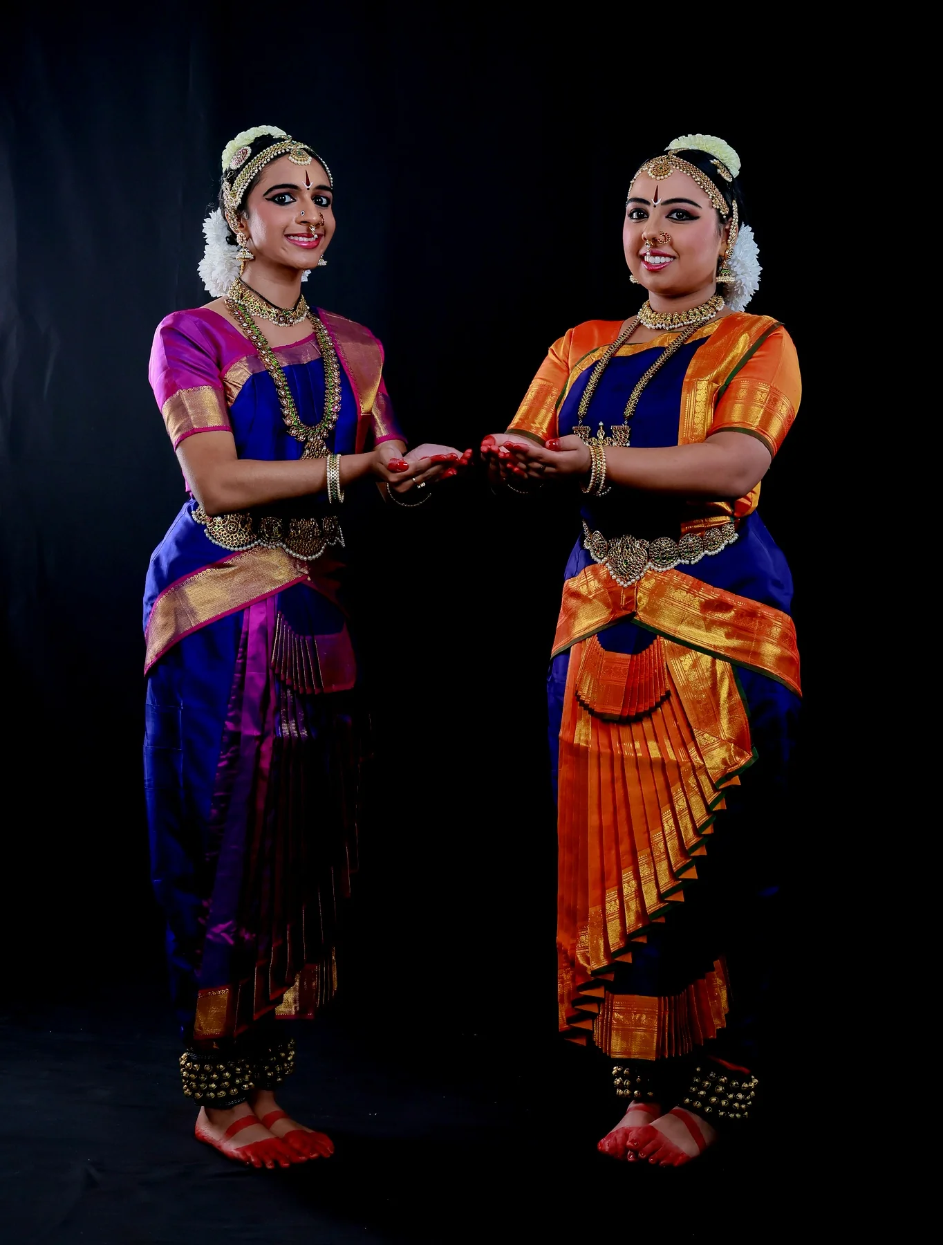 Shreya and Shriya with hands extended toward each other in a balanced Alarippu offering shape
